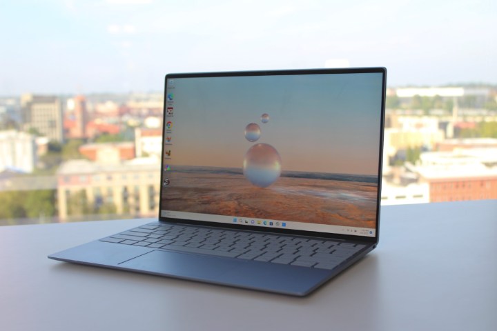 Dell XPS 13, mở trên bàn trước cửa sổ.