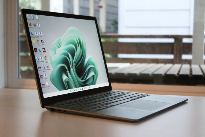 Surface Laptop 5 trên bàn trước cửa sổ.